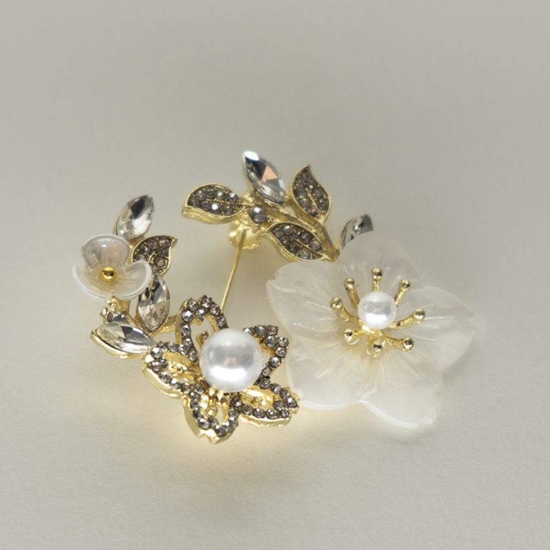 A gold brooch of blossoms and leaves set with pearls and clear crystals